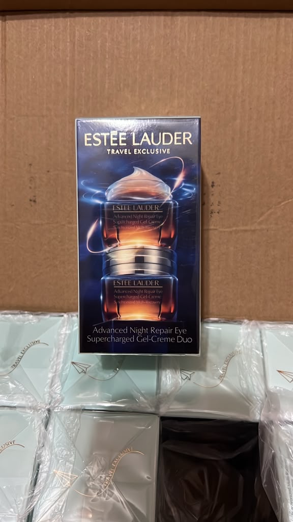 Estée Lauder Travel Exclusive Advanced Night Repair Eye Cream jar in its original blue packaging, displayed on top of a cardboard box with other wrapped products below.