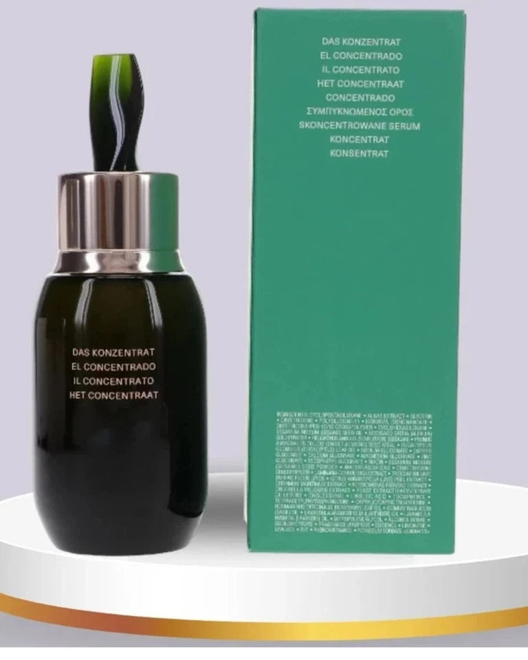 A dark green cosmetic serum bottle with a metallic silver dropper cap stands next to a tall matching green box on a white platform with a gold band, against a light gray background.