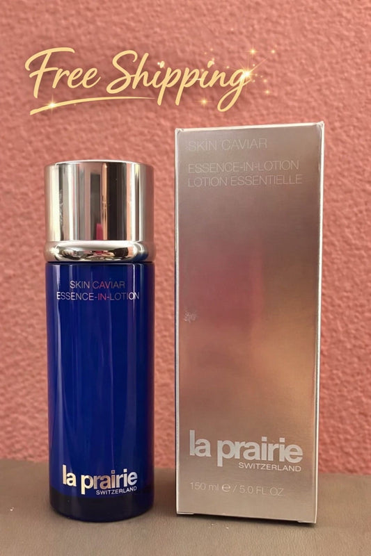 La Prairie Skin Caviar Essence-In-Lotion bottle in deep blue with a silver cap, shown next to its metallic silver box against a textured pink background with a 'Free Shipping' graphic overlay.