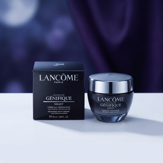 Lancôme Paris Advanced Genéfique Night cream jar with its black retail box, displayed on a white surface against a dark purple draped background.