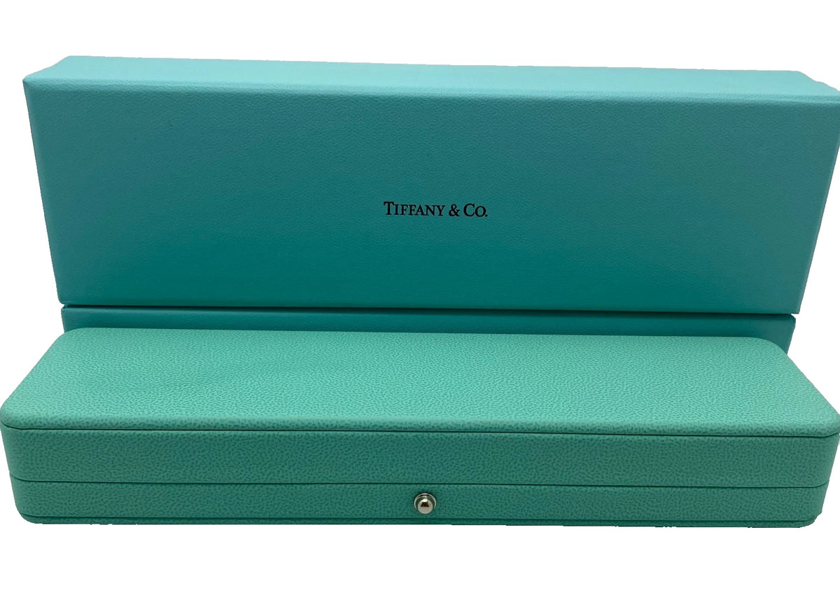 A turquoise blue textured leather jewelry box with the Tiffany & Co. logo embossed on the lid, shown open against a plain white background.