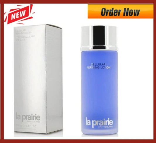 La Prairie Cellular Repairing Lotion bottle in light blue with a silver cap, shown next to its silver packaging box on a white background with 'NEW' and 'Order Now' promotional banners.